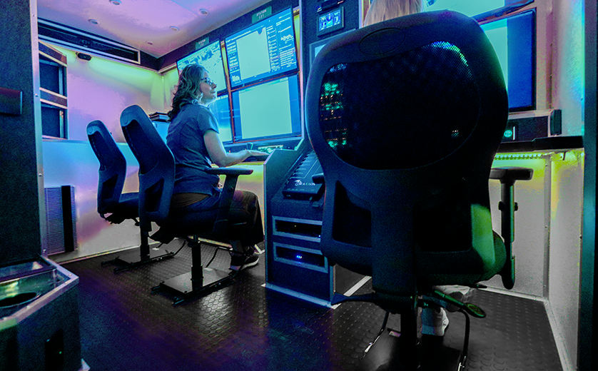 Three VanGo chairs with sliding jury bases with two women sitting in front of screens