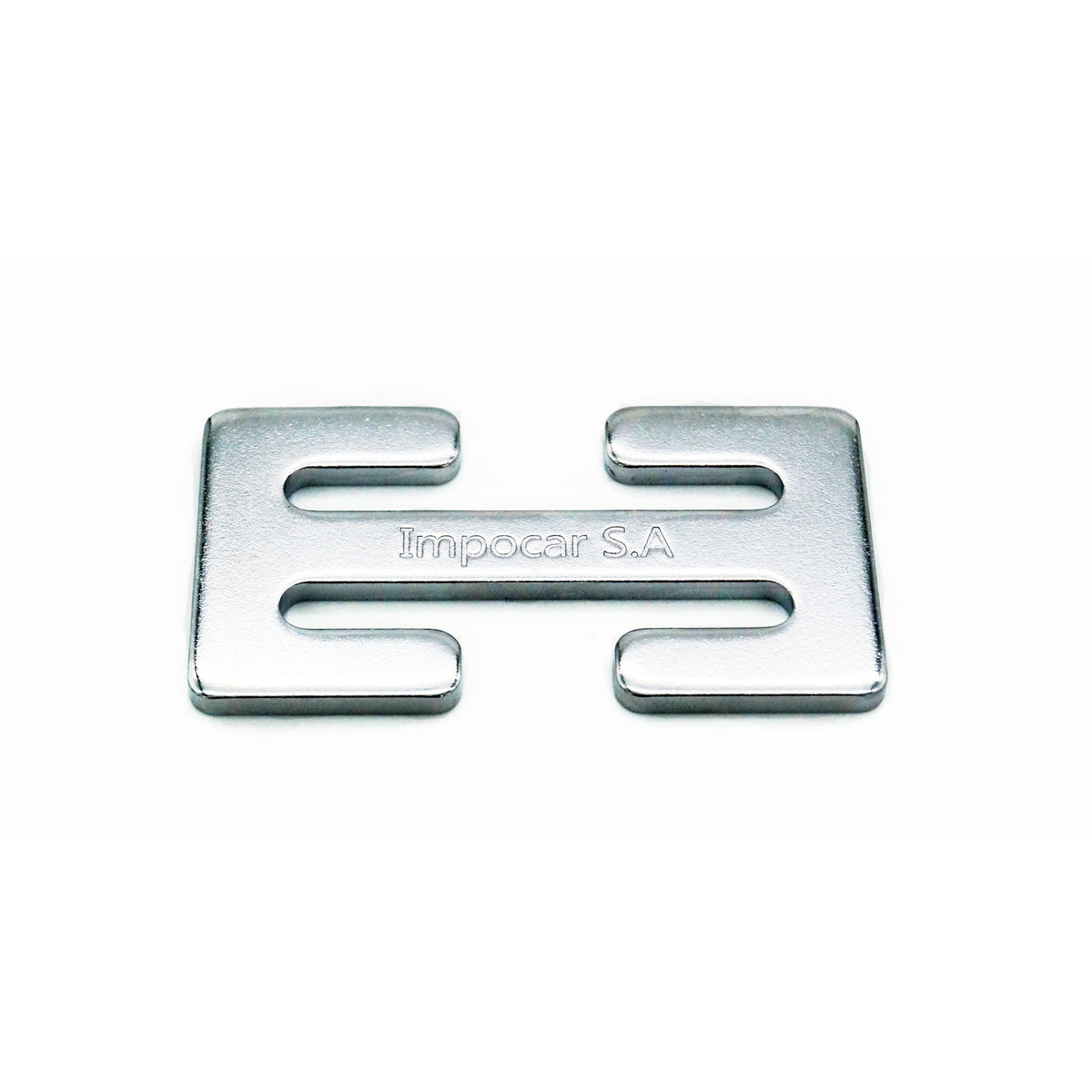 the horizontal view of a silver metallic seatbelt clip against a white background. The clip has two rectangular slots for the insertion of a seatbelt’s ends and is engraved with “Impocar S.A.,” 