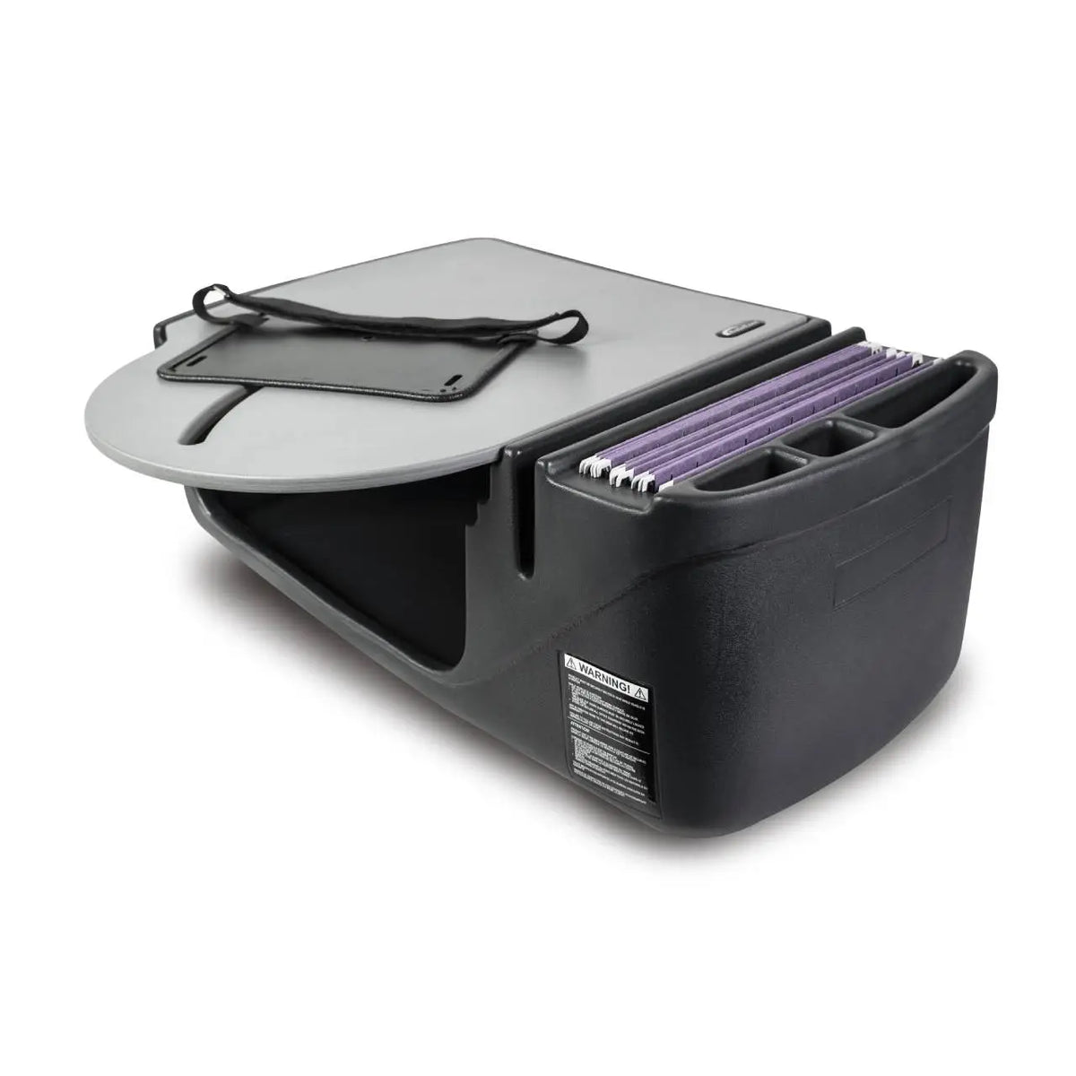 a car desk made of black plastic. It has a rounded flat top surface with a storage compartment underneath. The top has an elastic band to secure items, and the side features slots for holding files or documents. The desk is designed to fit on the passenger seat of a vehicle, providing a stable work surface while on the go