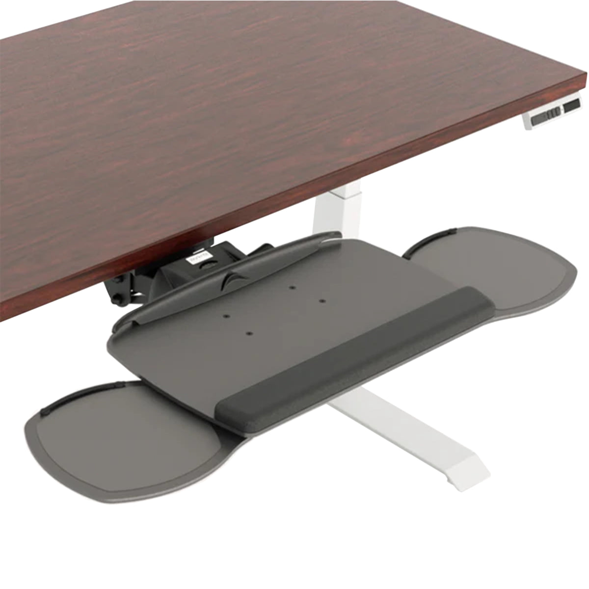 A dark gray under-desk tray with integrated wrist rest and two circular trays, shown attached to a white desk leg beneath a dark wood desk on a white background.