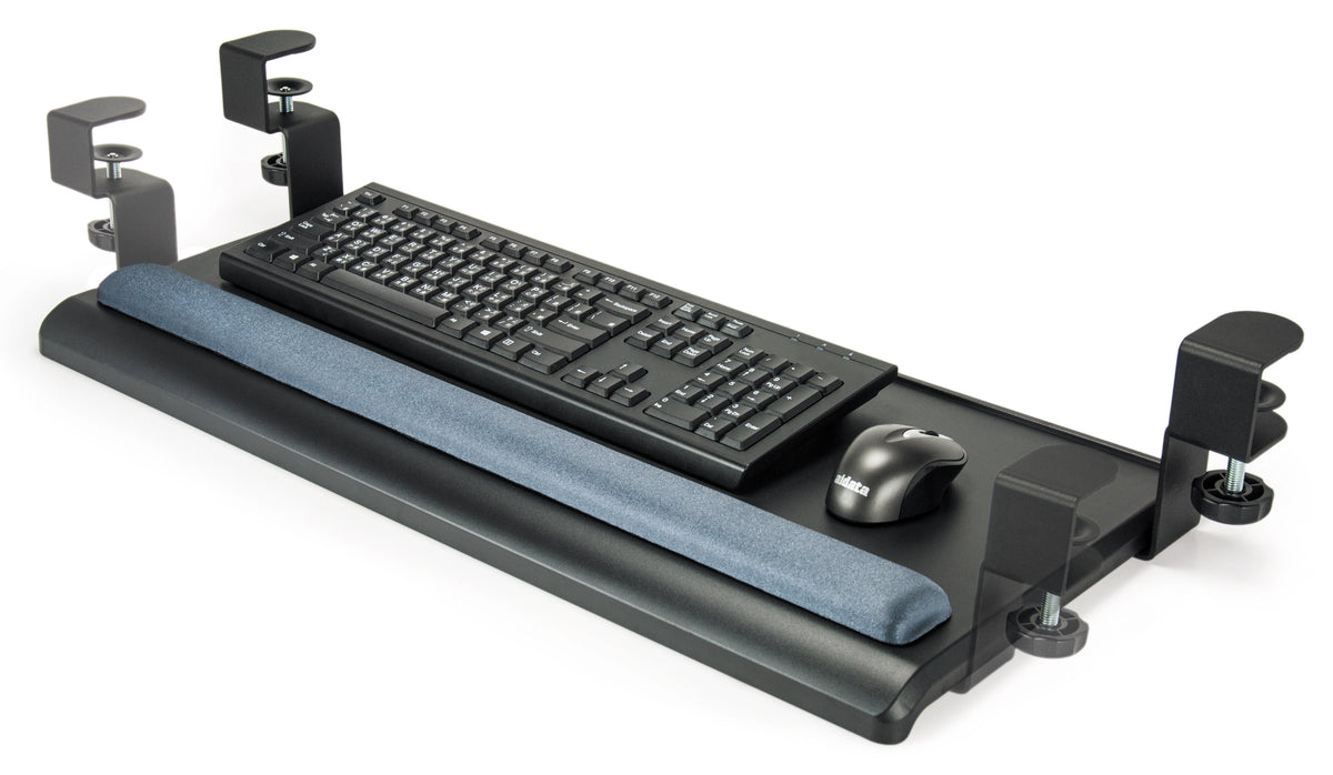 a black keyboard tray designed to attach under a desk. It features a flat, rectangular surface with rounded corners and a padded wrist rest along its front edge. The tray is supported by two metal clamps on either side, for adjusting as necessary. A sliver standard keyboard and black wireless rest on the surface