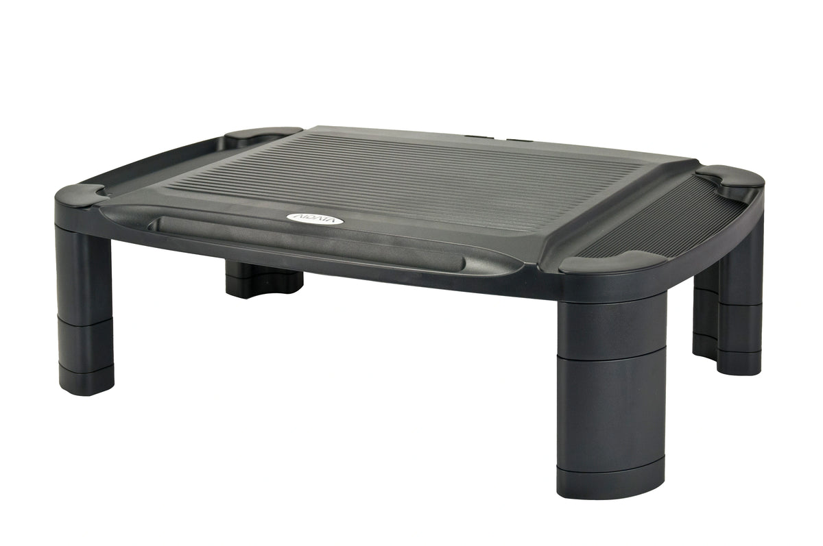 a rectangular, black plastic monitor stand with a textured top surface to support a monitor. There is a long divot intended for phones, tablets, pens, etc. The stand has four cylindrical legs at each corner.