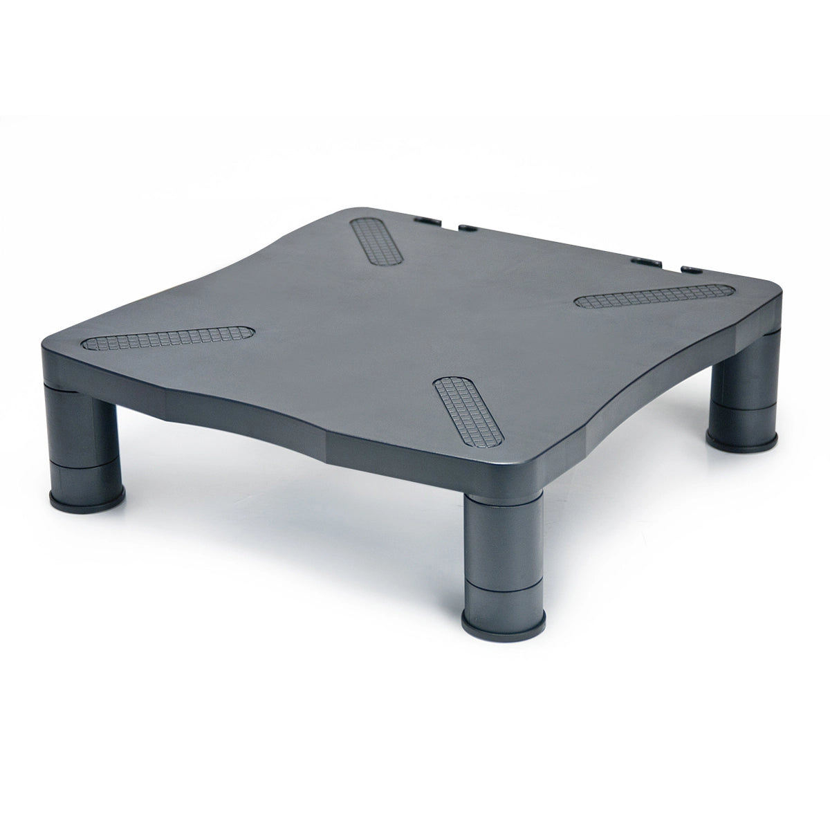 a sturdy black plastic monitor stand with a flat, rectangular top with rounded corners and is supported by four cylindrical legs. The top surface includes textured, anti-slip pads at each corner to secure the monitor in place