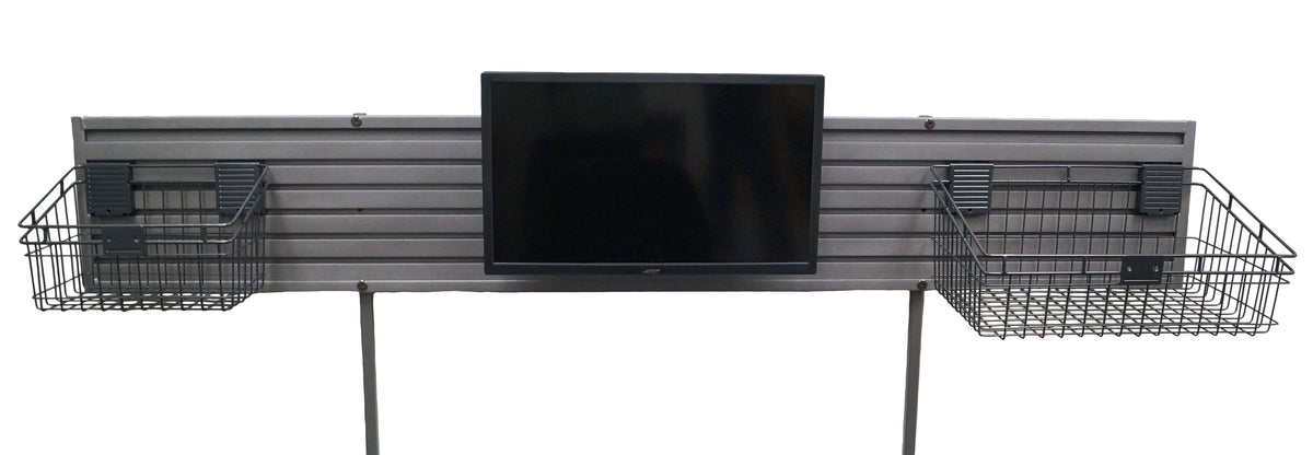 an extra long ridged piece of silver metal with 2 long metal posts, designed to mount to a desk, screwed to each end. A black computer monitor is mounted to length of metal in the middle, to each side a black metal basket is mounted. The basket on the right is larger than on the left. 