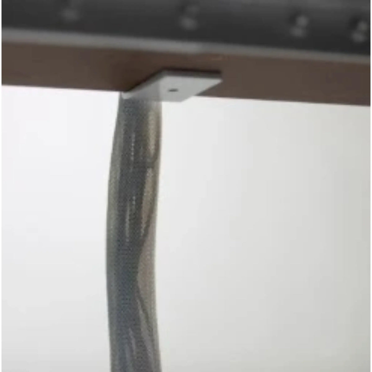 Close up of under the desk where the 
Vertical Mesh Cable Sleeve connects to the desk