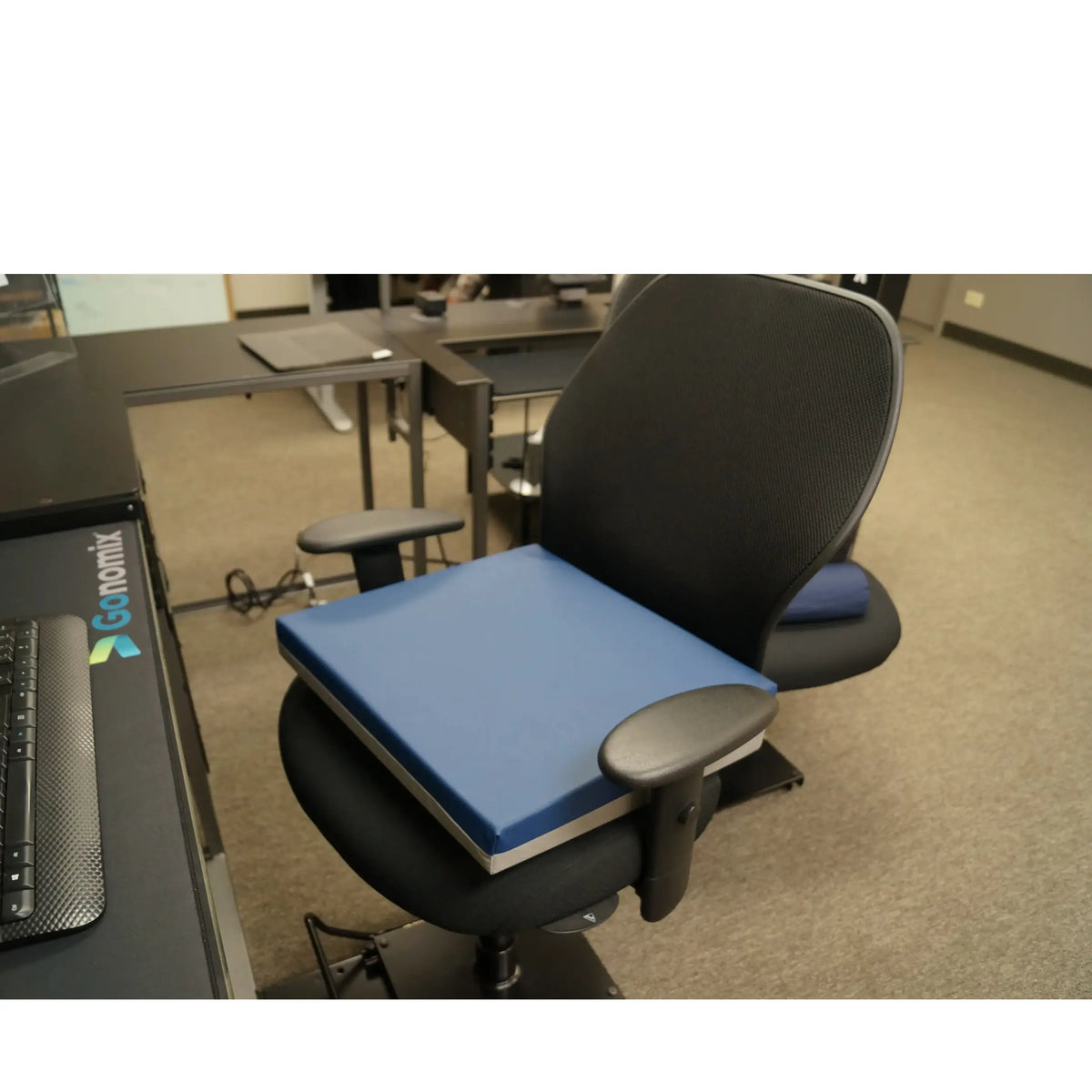 Ergonomic office chair with a wedge seat cushion in an office setting