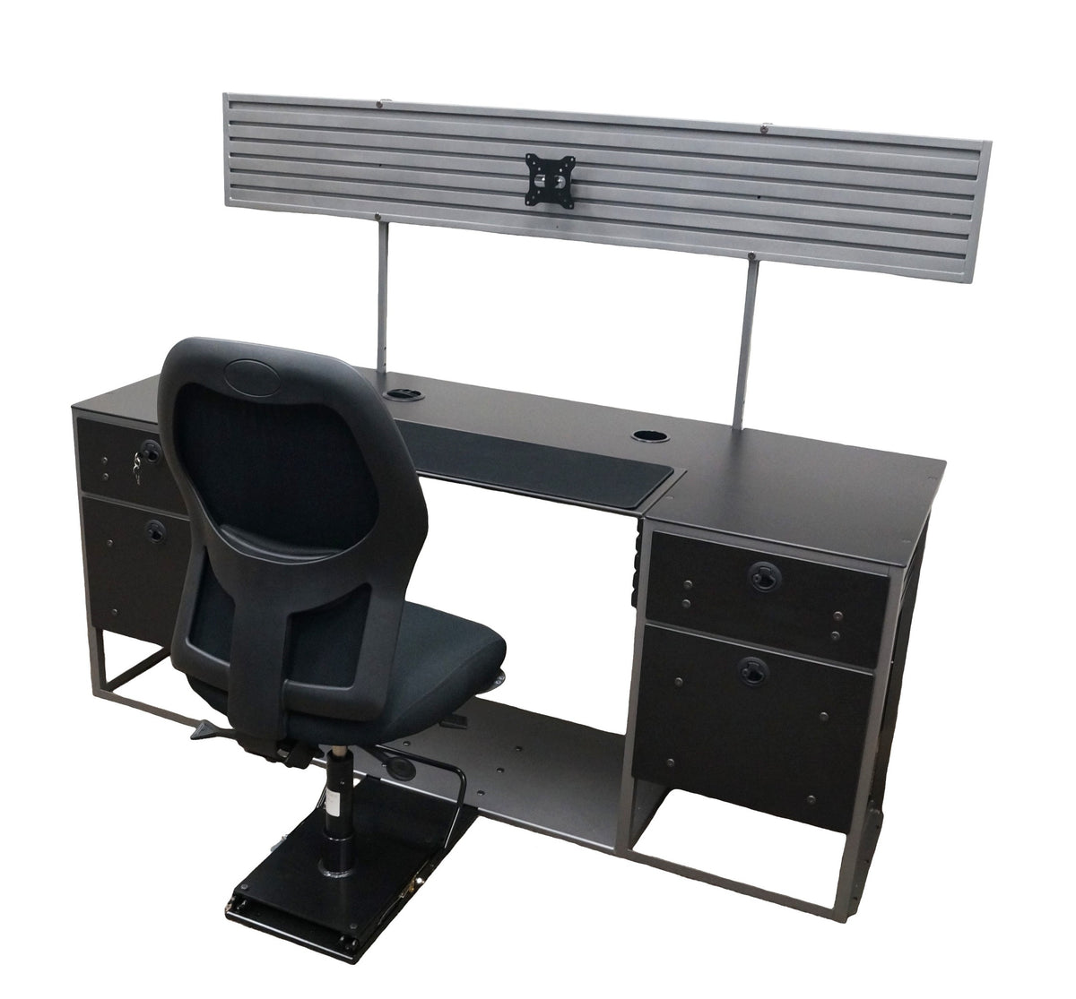 A large flat desk with a black work surface, a hutch, and a connected black chair mounted on a black sliding seat base. The surface features black fabric in the middle and two empty grommet holes. Mounted to the back of the desk is a large gray hutch with groves and a monitor mount. The base of the desk is made of 2 sets of black drawers on each side of an open space for the chair. The bottom of the desk is connected together with a large sheet of gray metal to which the sliding black chair is mounted. 